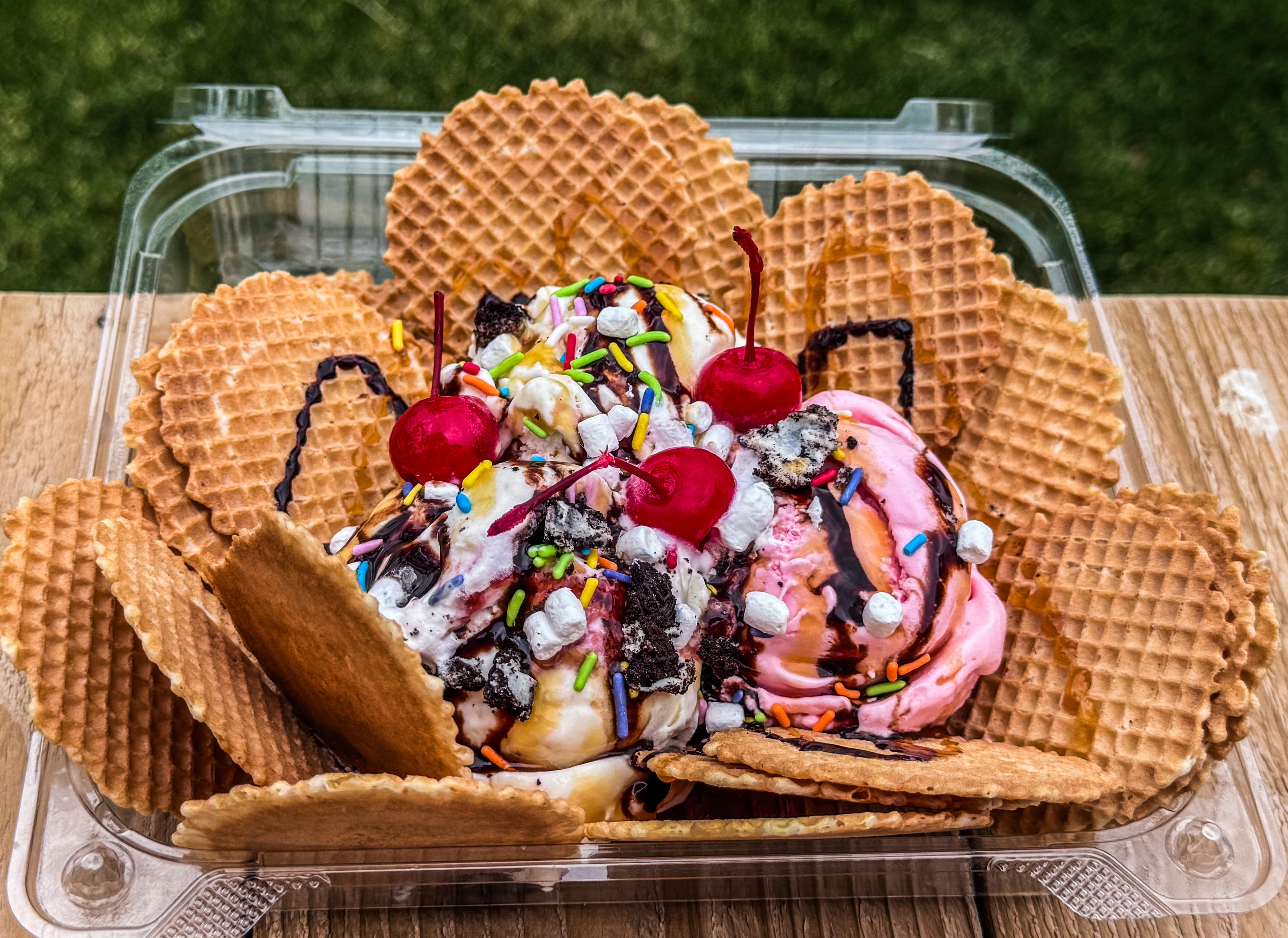 Ice Cream Nachos — a clamshell of waffle chips piled with scoops, cherries, sprinkles, and chocolate sauce